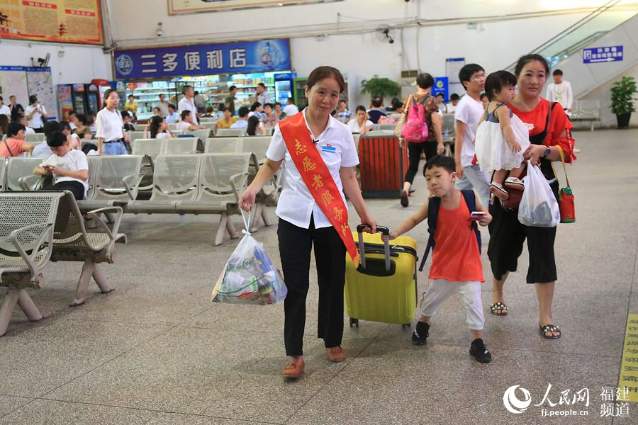 陳萍幫助乘客托運行李  鄒家驊攝