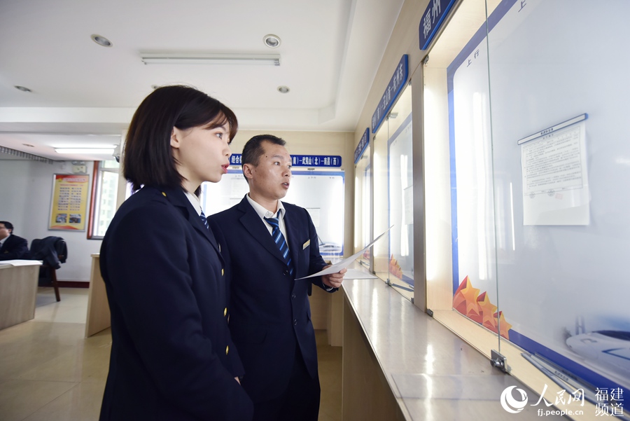 劉純與師傅劉斌共同核對“運行揭示”，確認途中有沒有限速等情況。 余杉芳攝