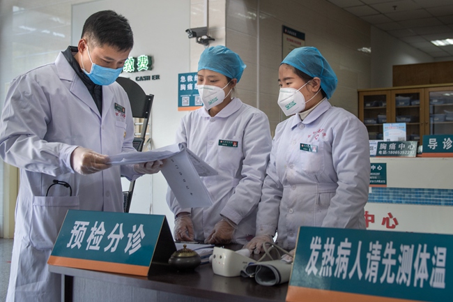 林孟新（左一）到預檢分診、發熱門診、隔離病區一線踩點檢查。 張文慶 攝