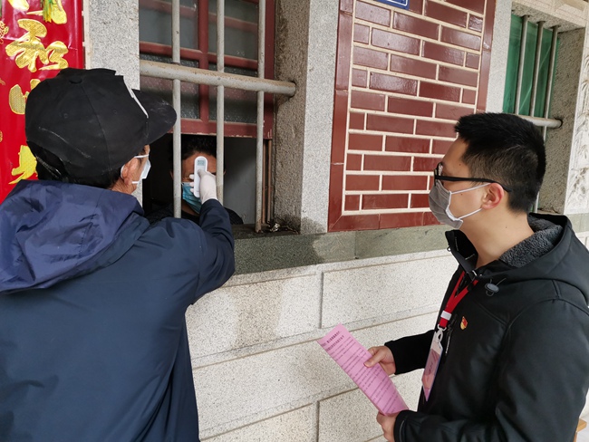 橋隧中心駐大廈村寇貴萍和村干部正在給隔離人員測量體溫，入戶宣傳。劉紫燕攝
