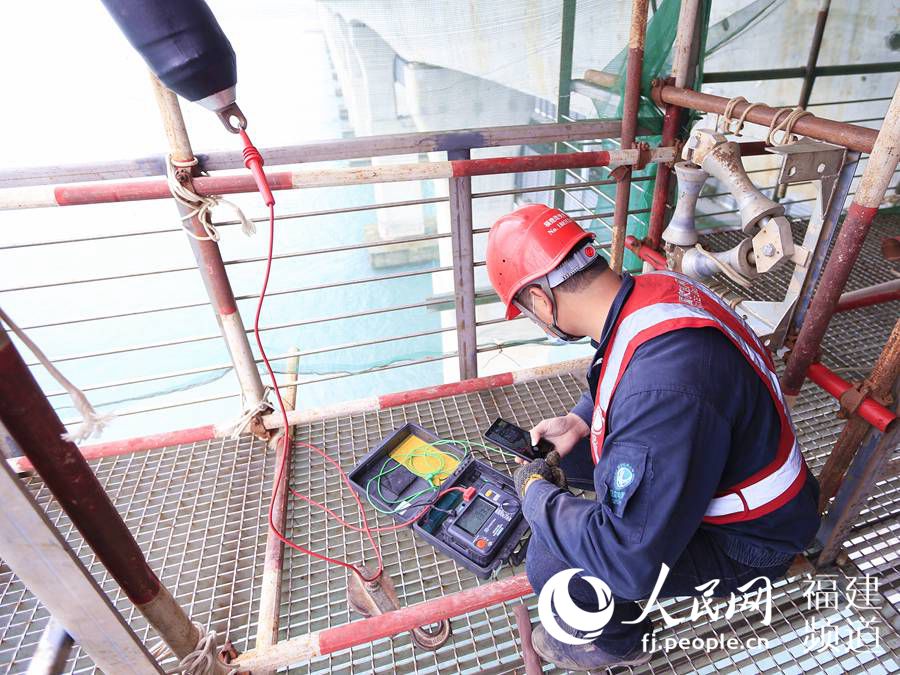 福建送變電公司施工人員在平潭公鐵大橋臨空施工平台上對橋纜進行絕緣測試。.