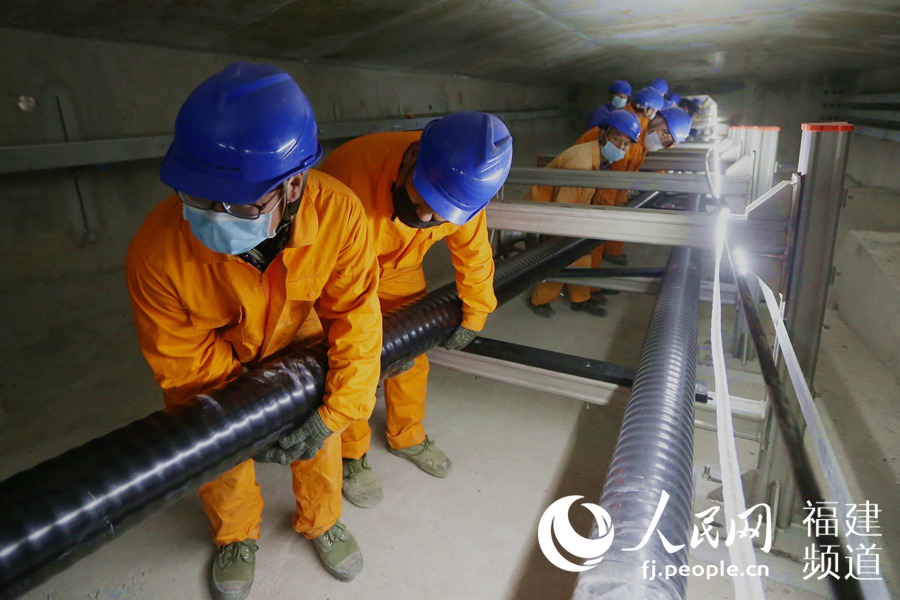 福建送變電公司施工人員在平潭公鐵大橋橋腹箱涵內進行220千伏橋纜敷設施工。