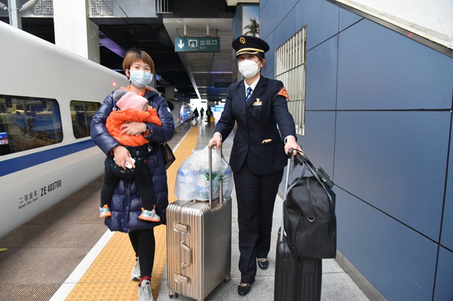 福州火車站值班站長趙靜推著行李箱護送曹女士進站乘車。江曲攝