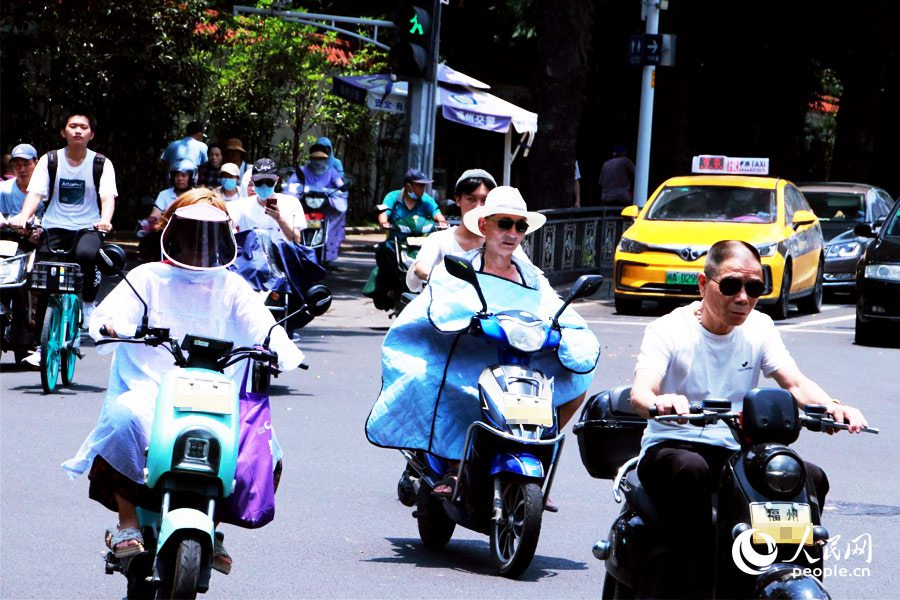 在福州市街頭，隨處可見市民出行“全副‘捂’裝”，做好了防暑防晒的保護措施。人民網 劉卿攝