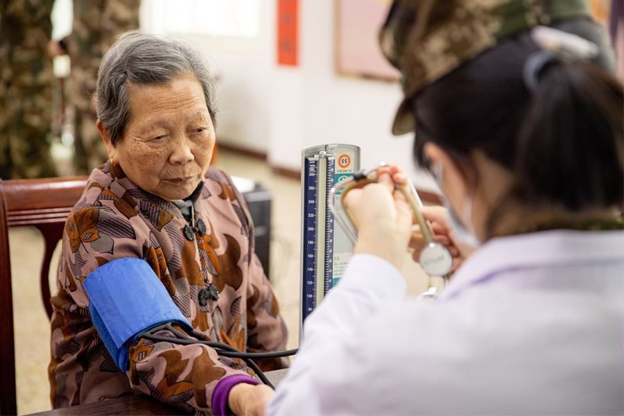随行军医为老人们测量血压、验血，并免费为他们提供常用药品。蔡子梦摄