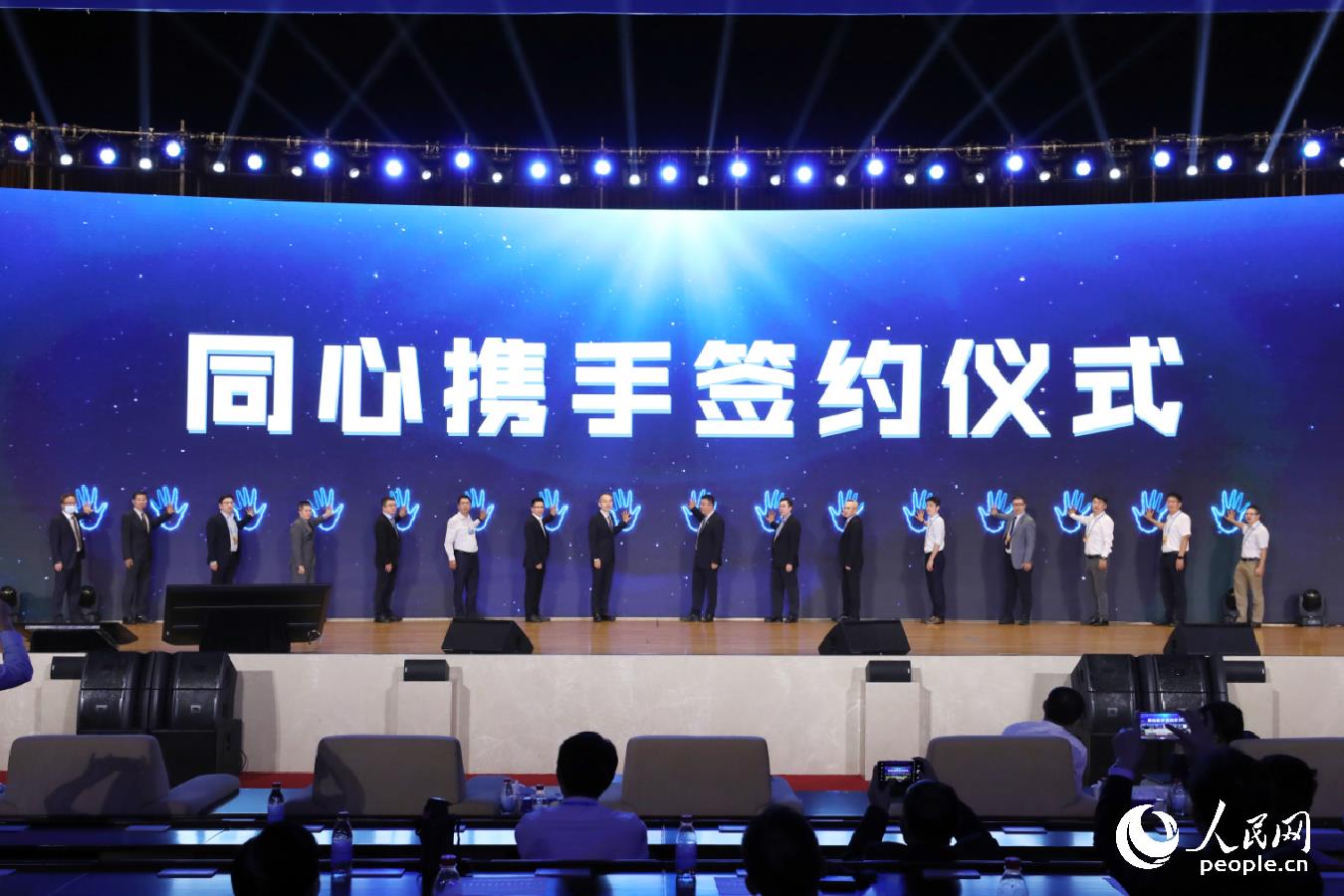16家企業代表共同在“同心攜手”簽約儀式上啟動大屏。人民網 陳永整攝