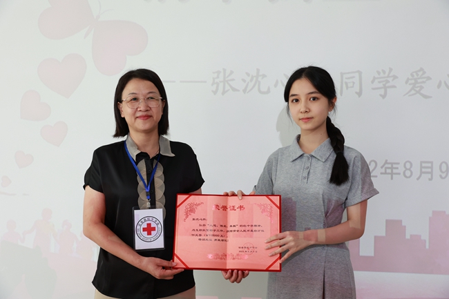 张沈心然(右)接受诏安县红十字会颁发的捐赠证书。钟晓霞摄