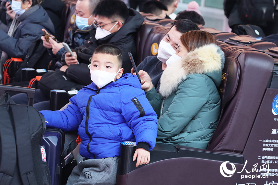 候车厅里,一家三口等车回家。人民网 刘卿摄