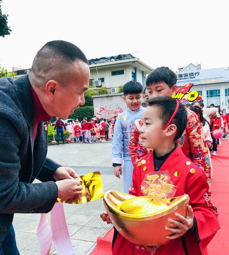福州市仓山区第四中心小学校长给学生贴“金点点”，寓意兔年吉祥健康，大展宏图。福州市仓山区第四中心小学供图