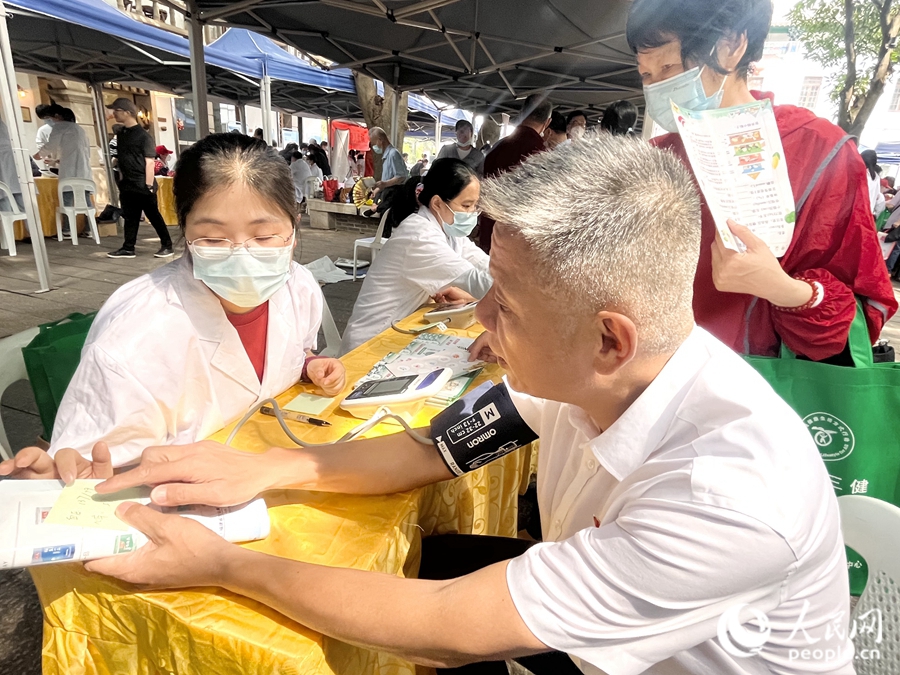 一位市民在展位前測量血壓。人民網 錢嘉禾攝