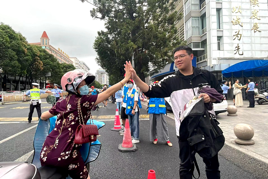 8.高考首日，送考家长与考生击掌祝福。毛朝青 摄
