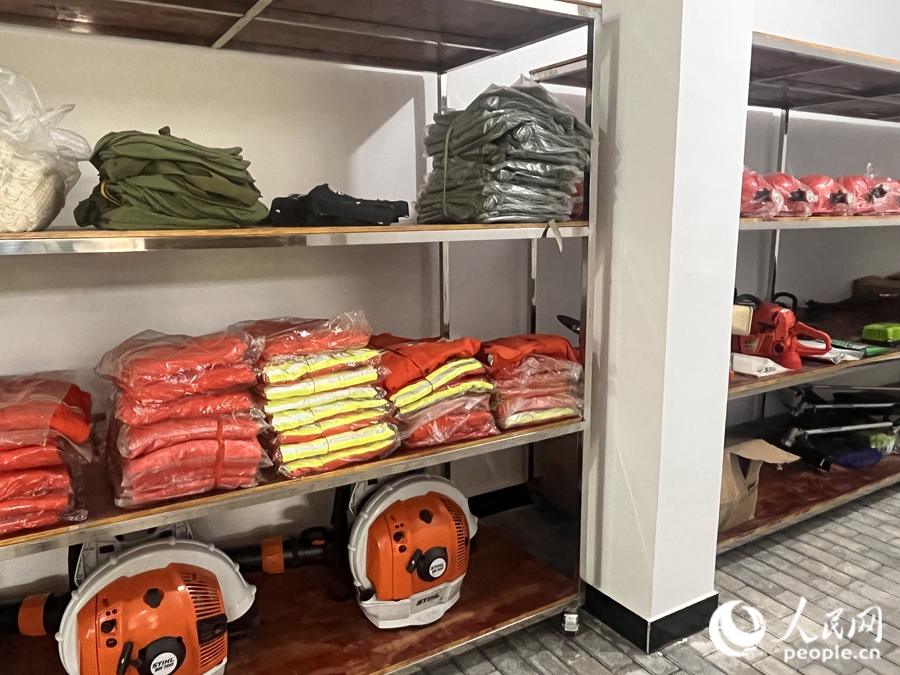 消防服、救生衣等各类应急装备器材被整齐地摆放在应急储备中心的铁架上。人民网 钱嘉禾摄