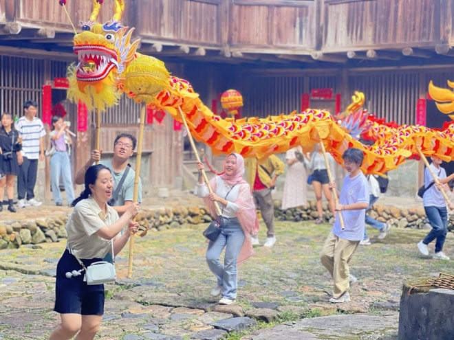 活动中，专家及学生一行深入南靖土楼景区，学习体验非遗项目和文化展示活动。南靖县融媒体中心供图