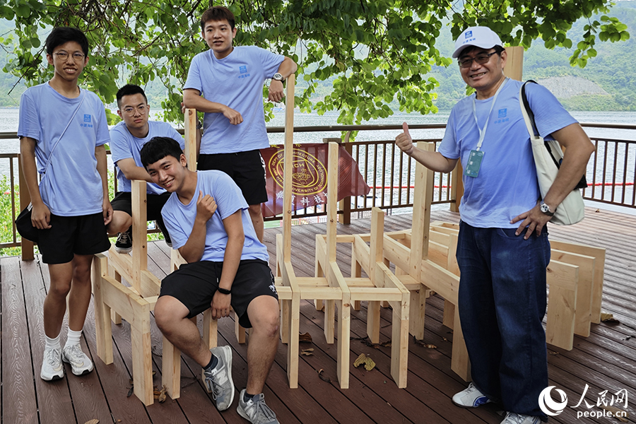 8月9日,“中建海峡杯”第十届海峡两岸大学生实体建构大赛现场,来自华夏科技大学建筑系的参赛选手和在他们搭建的题为《禹岳》的作品前合影。人民网 黄东仪摄