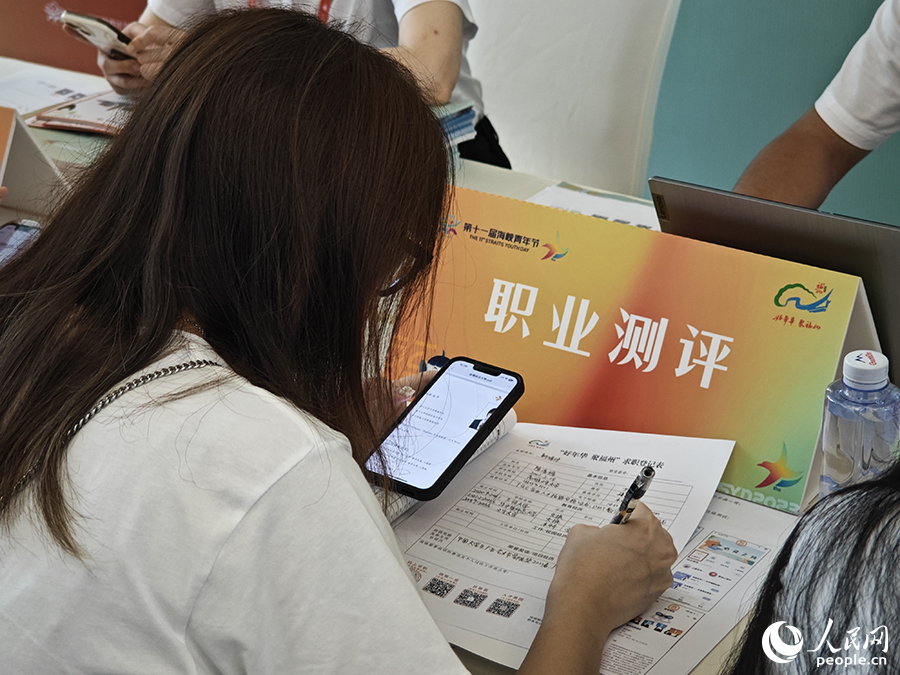 8月10日,“好年华·聚福州”2023年闽台青年人才研学营招聘会现场,一位台湾青年正填写求职材料。人民网 黄东仪摄