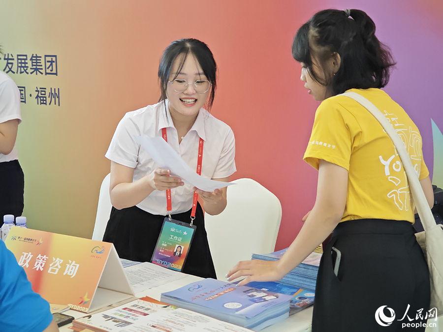 8月10日,“好年华·聚福州”2023年闽台青年人才研学营招聘会上,工作人员热情地向台湾青年介绍福州市为便利台湾青年来榕就业创业出台的优惠政策。人民网 黄东仪摄