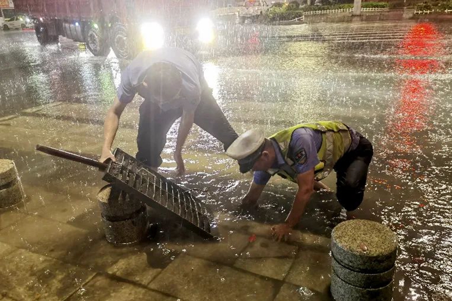 莆田市涵江区交警大队民警对城涵东大道积水严重区域进行清淤排水。莆田市公安局供图