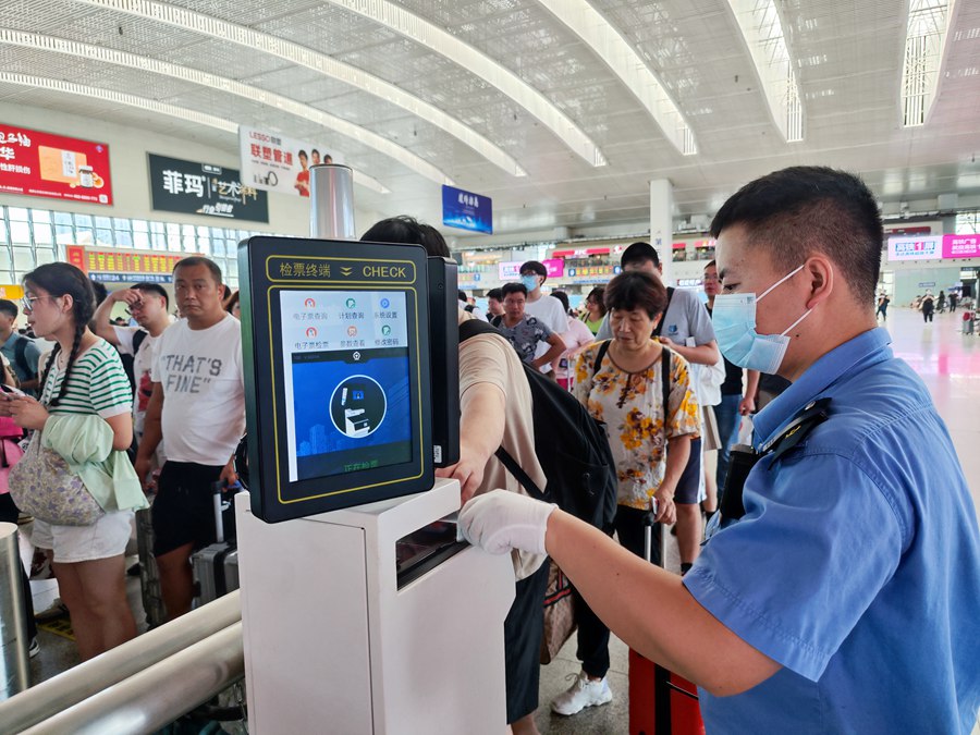 工作人员引导旅客检票进站。韩毅摄