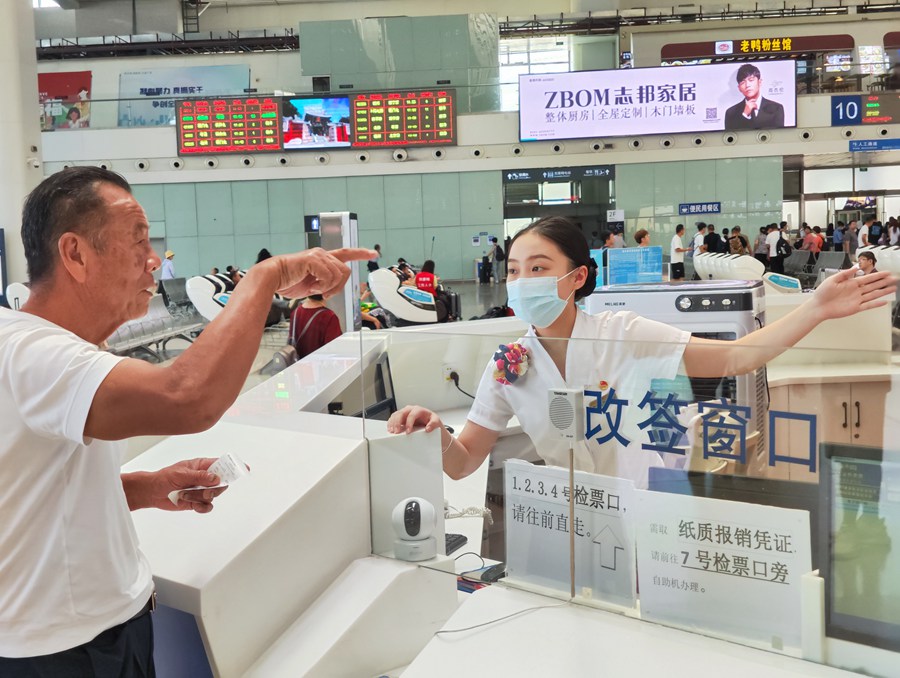 服务台工作人员为旅客解答咨询。韩毅摄