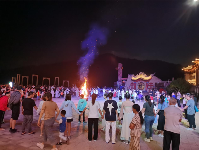 游客在侠天下景区的篝火晚会上跳舞。张家炎摄