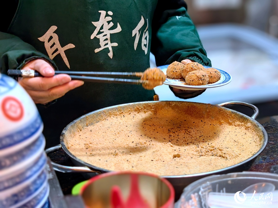 芝麻糍又叫做“米时”（福州话音为“ci”），是大米和糯米按一定比例混合，磨成浆，压成半干后搓成的圆形丸子，煮熟后裹豆粉、芝麻、糖等，即可食用。人民网 叶青卿摄