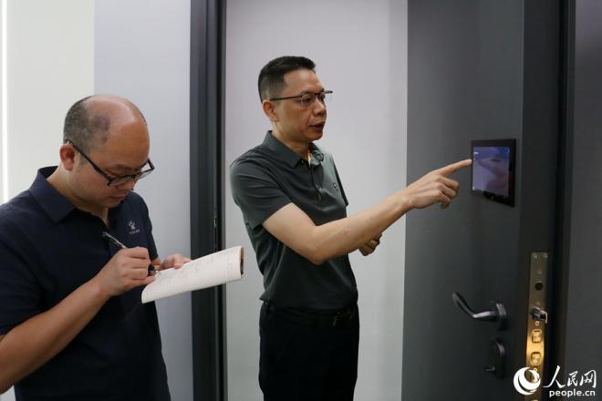 施米德科技负责人正在介绍一款创新型智能门。人民网记者 陈博摄