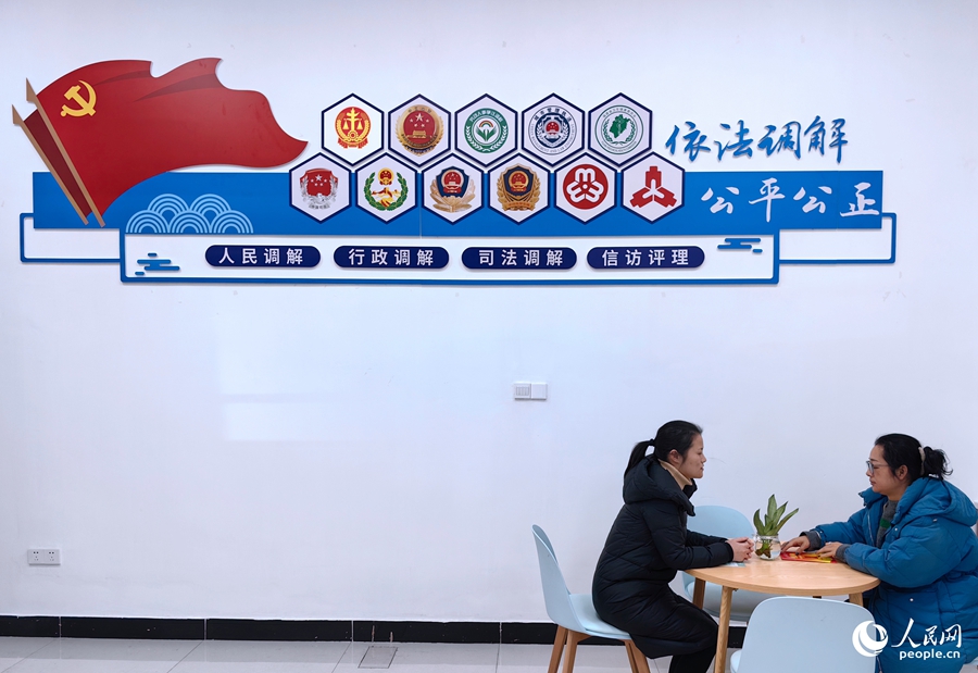 将乐县“一站式”多元调解中心的一面墙上挂着十个成员单位的标识，便于来访群众快速选择判断。人民网 叶青卿摄
