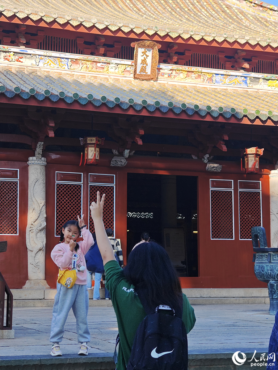 2024年1月18日，游客在文庙大成殿前拍照留念。人民网 黄东仪摄