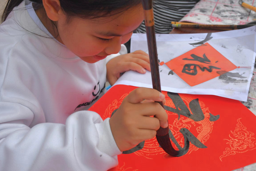 在檳榔社區,小女孩拿起毛筆書寫“福”字。楊金木攝