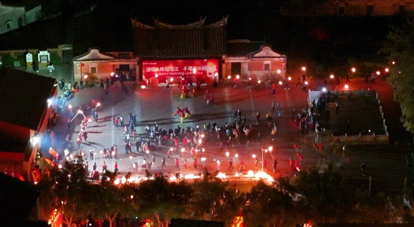 成百上千的村民手持点燃的油炬,沿村道行进