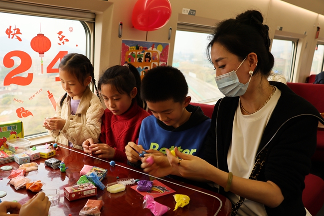 高铁列车上，家长带孩子在”遛娃舱“玩玩具。陈月 摄.jpg