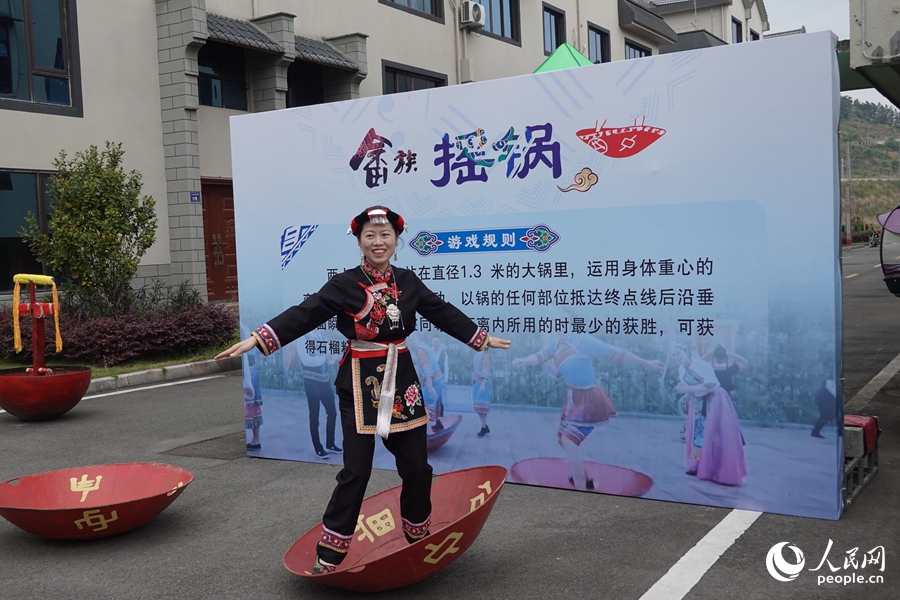 游客在现场体验畲族传统运动项目“摇锅”。人民网 杨灏昱摄