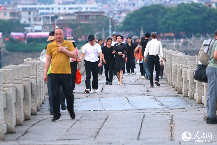 四面八方的游客汇聚于洛阳桥畔，感受古桥的魅力。人民网 李昌乾摄