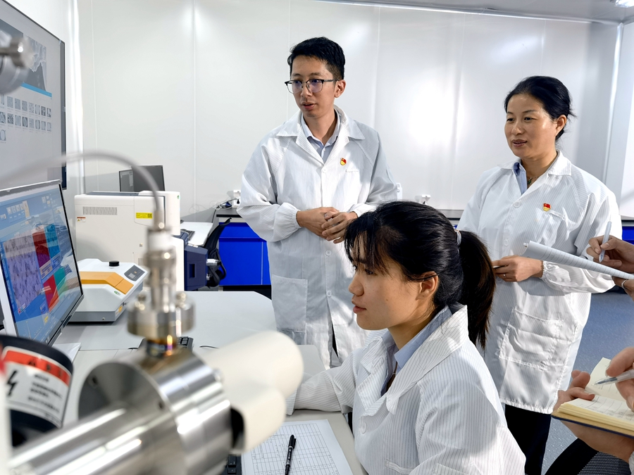 廈鎢新能研究院副院長魏國禎與同事討論生產、研發問題。廈鎢新能供圖