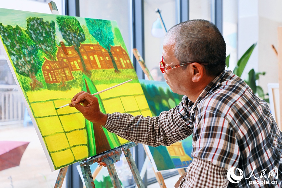 周天行在繪畫創作中。人民網 李唯一攝