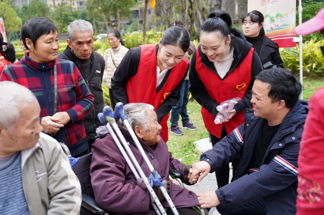 志愿者与百岁老人亲切交谈。中建海峡供图