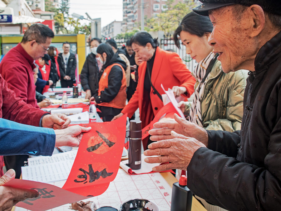 槟榔社区工作人员将写好的春联递到居民手中。杨金木摄