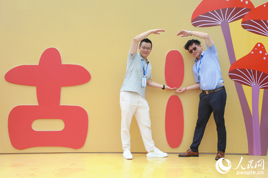 两位游客在展区打卡点用肢体拼凑成古田的“田”字。人民网 李唯一摄