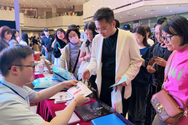 现场观众排队领取集友银行支票明信片周边