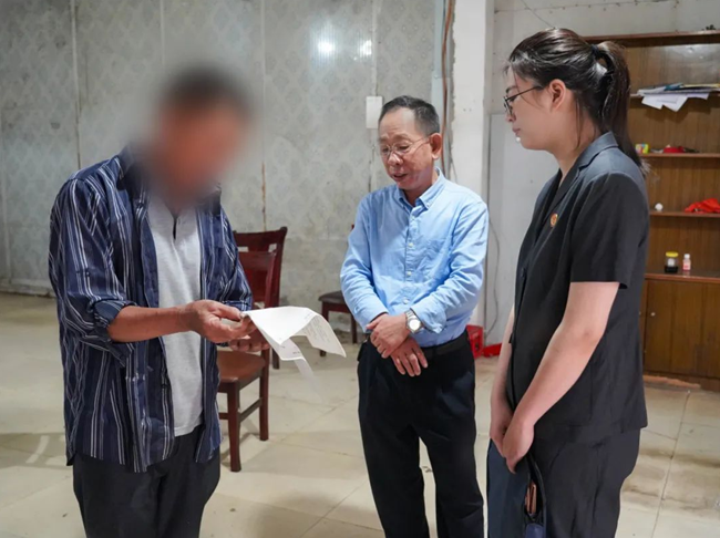 在调解员黄进勤（中）的主持下，老陈就租赁合同和居委会达成逐步搬迁的调解协议。集美法院供图