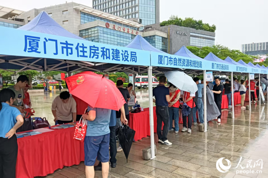 虽然大雨滂沱，但46家参与单位的工作人员依然热情满满，为前来咨询的市民群众耐心解答问题。人民网记者 陈博摄