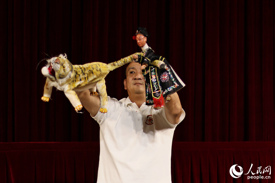 漳州布袋木偶戏的一大特点是可以一人同时饰演两个不同角色，“两手对打”。图中是《武松打虎》片段表演。人民网 李昌乾摄