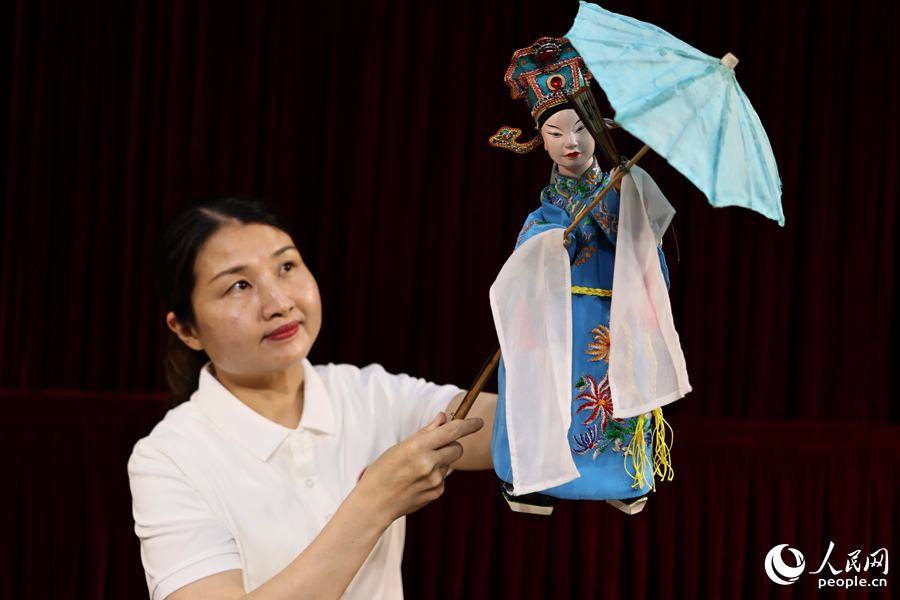 布袋木偶可以完成撑伞、开扇、顶碗等细致人物动作。人民网 李昌乾摄