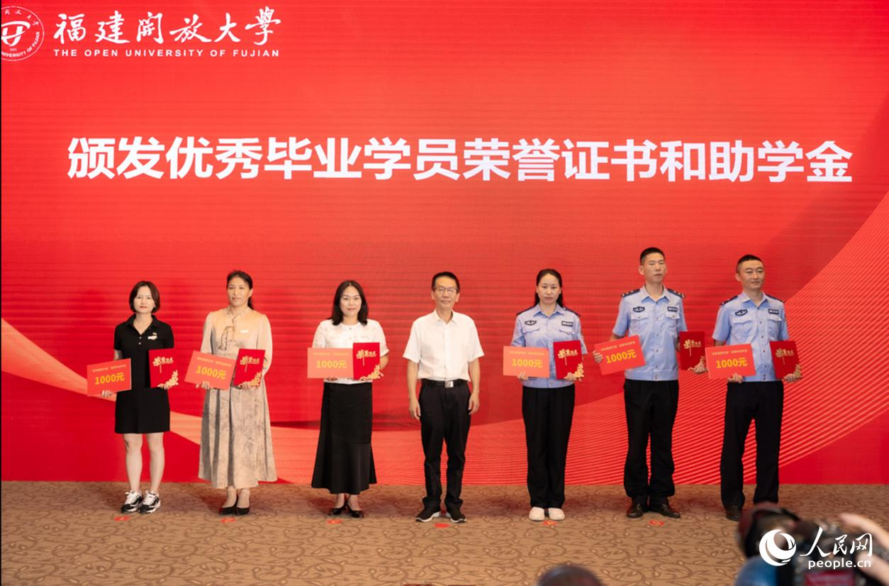 福建省总工会副主席方月兴为劳模本科班优秀毕业学员代表颁发荣誉证书和助学金。实习生 魏建烨摄