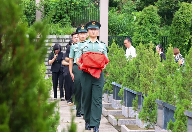 礼兵双手托举烈士棺椁，护送至墓位