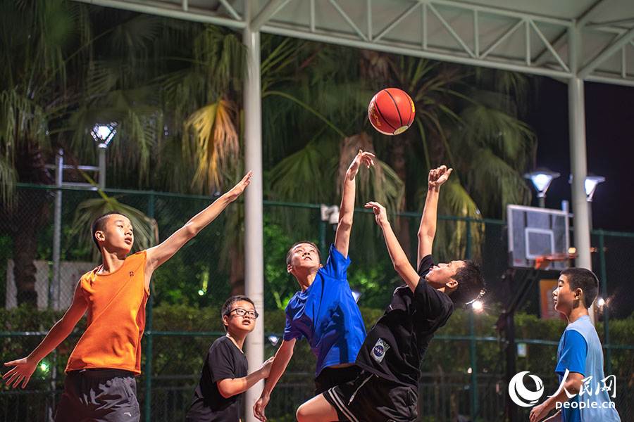 7月15日，位於福建福州的福建省奧林匹克體育中心，一群孩子正在夜色下打籃球。實習生 魏建燁攝