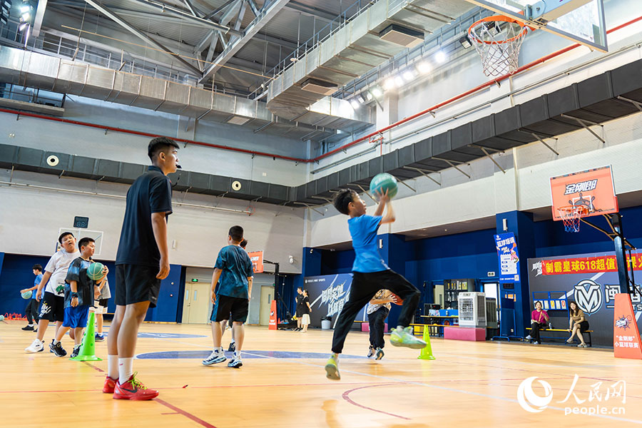 7月13日，位於福建晉江的安踏全民健身運動中心籃球館內，學生在暑期籃球訓練營中進行籃球基本功訓練。實習生 林靜茹攝