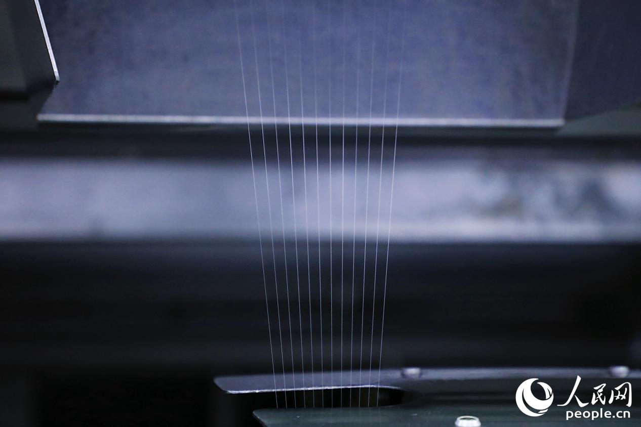 锦纶纱线在纺织设备上高速运转。人民网 李唯一摄