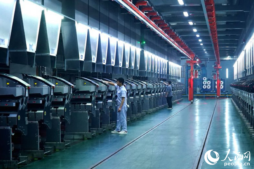 工作人员正在维护生产车间内的智能化设备。人民网记者 兰志飞摄