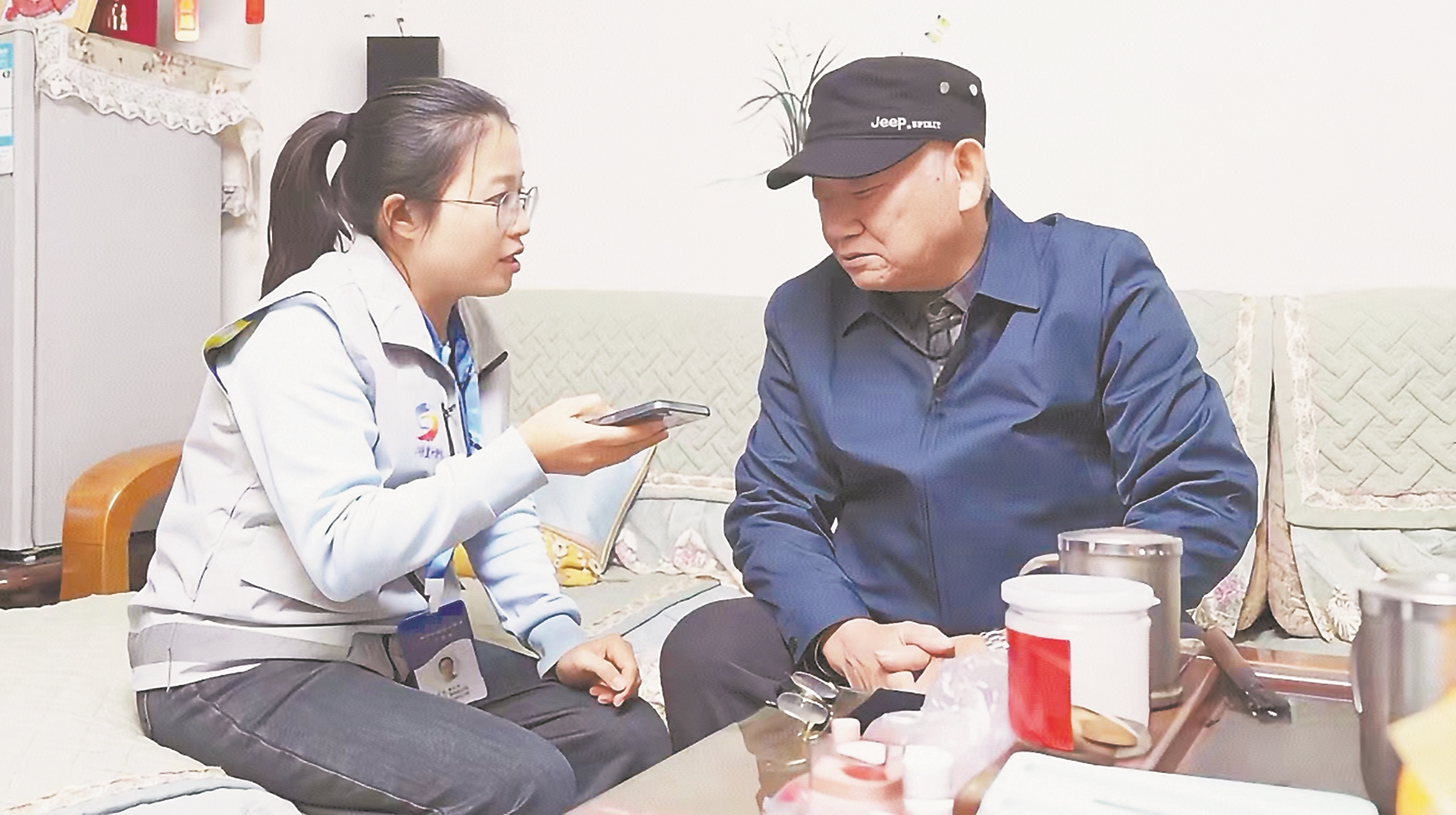 网格员上门为居民讲解医保参保相关政策。（资料图片）